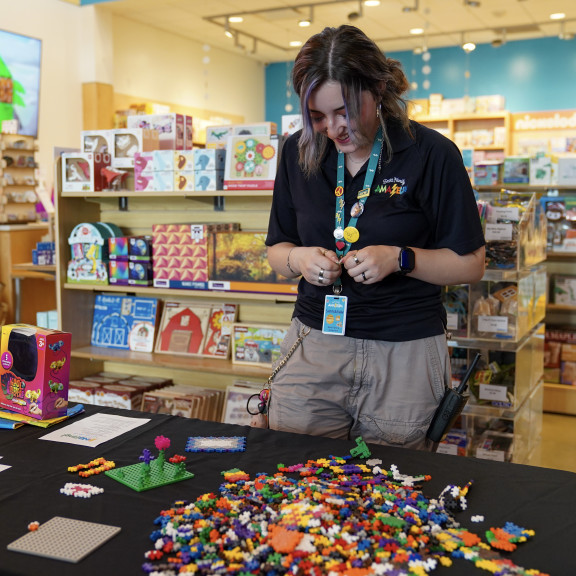 Amazeum Employee In Front Of Table With Legos