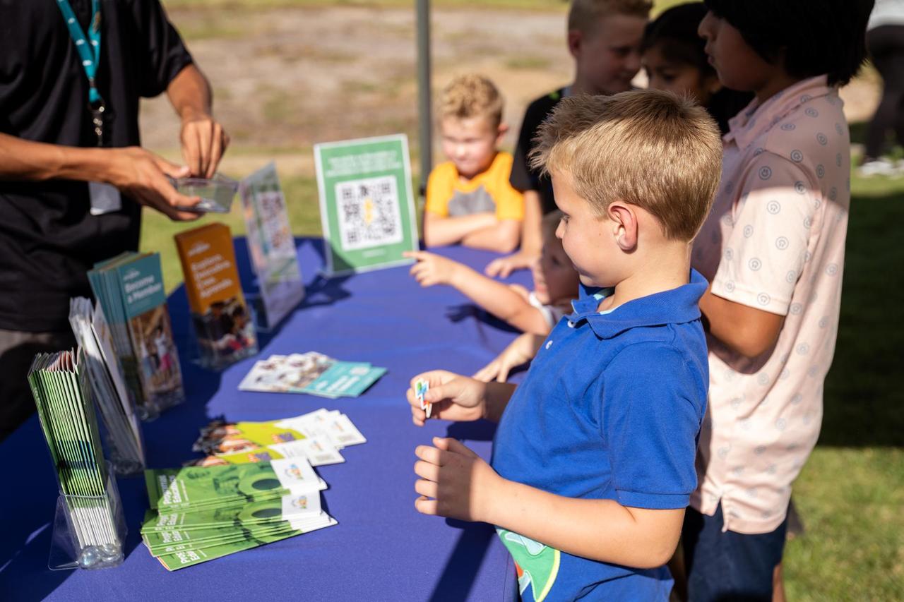 Boy Standing At Table With Amazeum Sticker