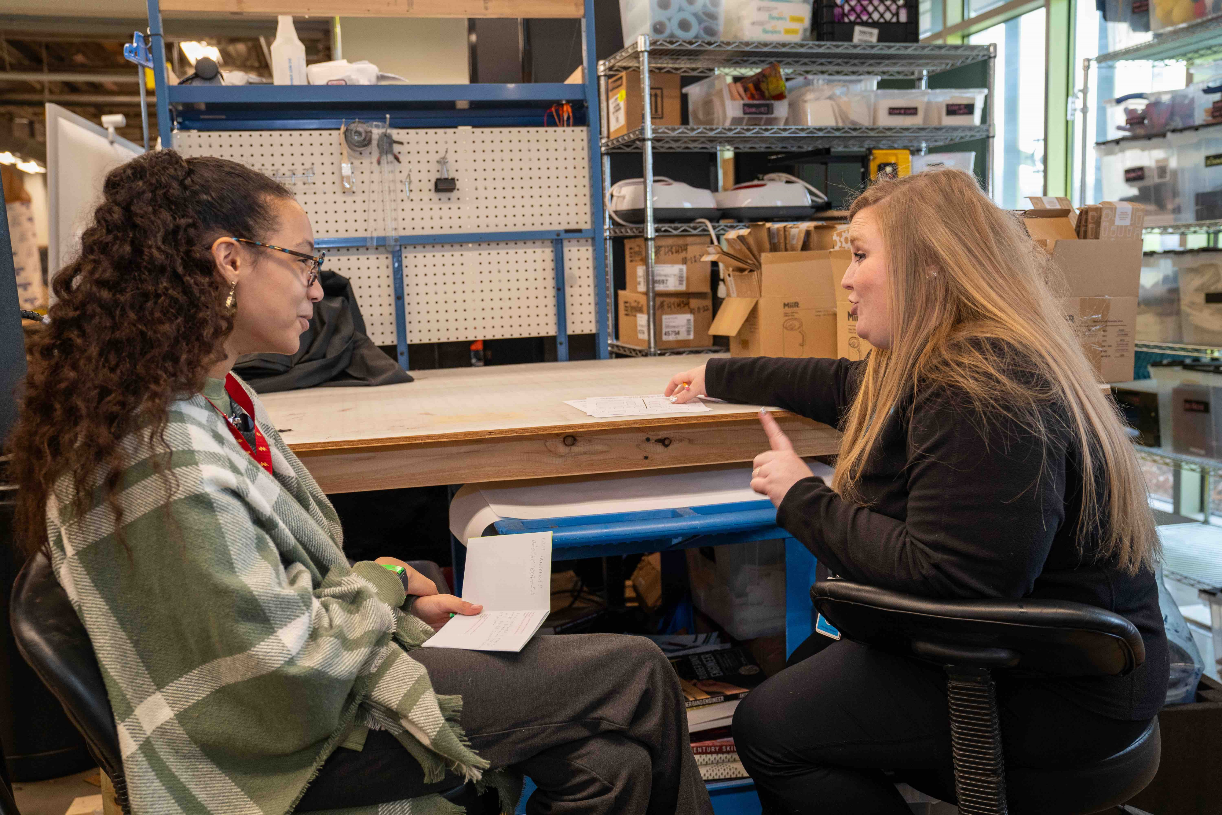 Teenage girl talking with an Amazeum team member about her Youth Maker Market creations