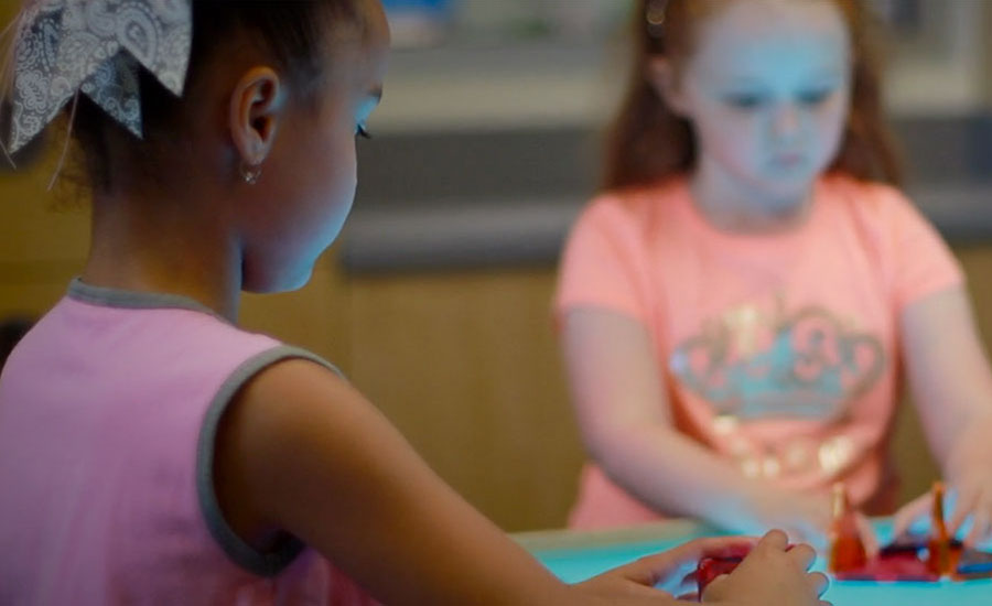 Two Children Playing With A Project On An Unfield Trip