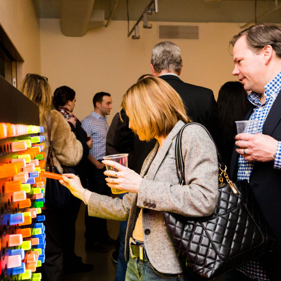 Adults Playing With Giant Pegboard Exhibit