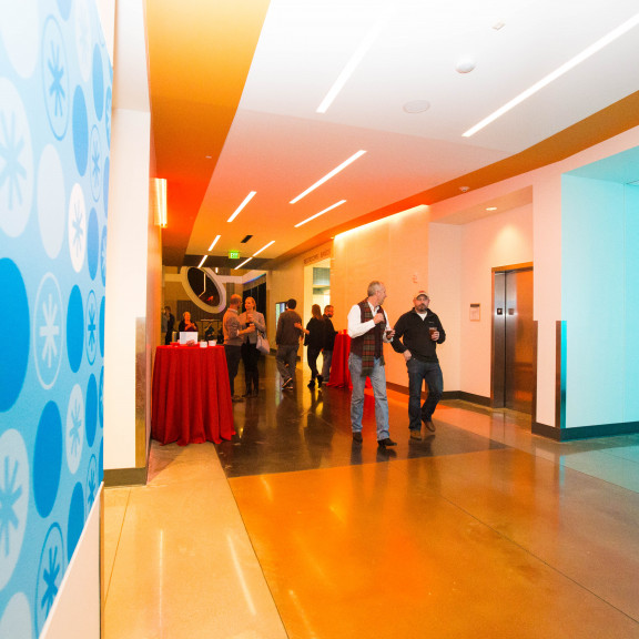 Two People Walking Down Amazeum Hallway During Event