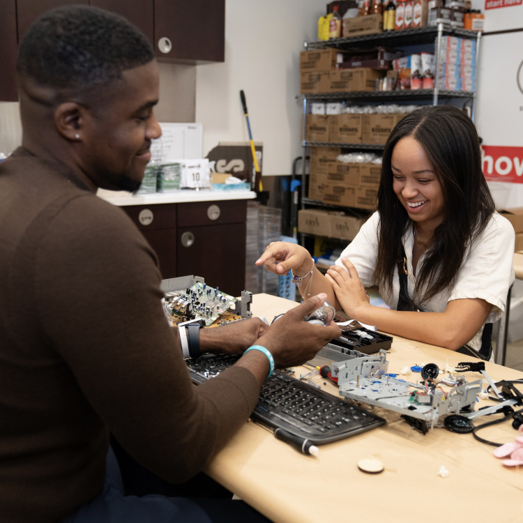 Two Adults Working on Electronics Project Together