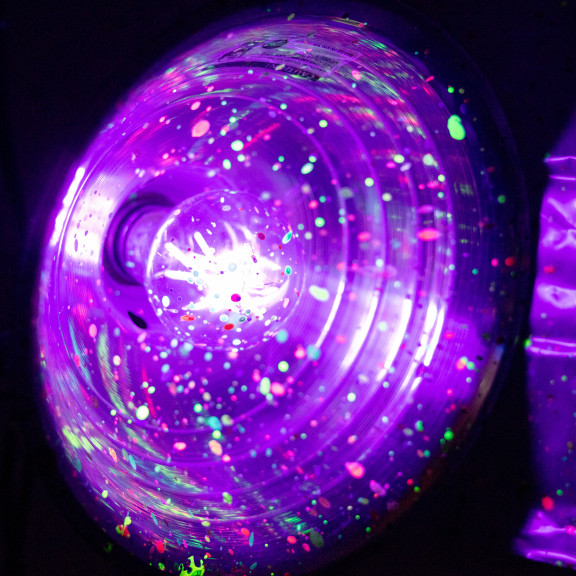 Close Up Of Black Light With Glow Paint Splattered On It