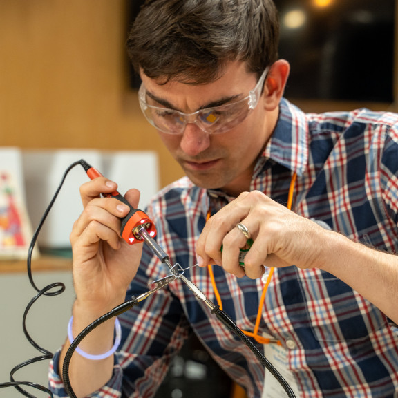 Man Soldering Two Wires Together