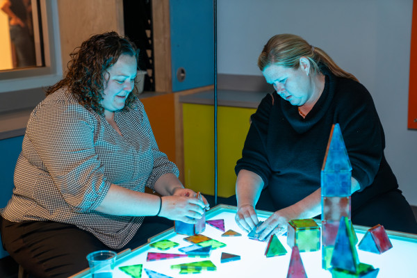 People Playing With Shapes On Illuminated Table