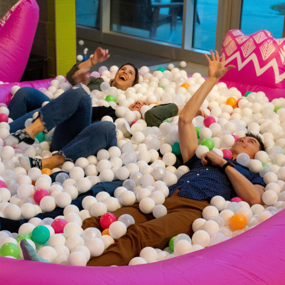 Two Adults Playing In Giant Ball Pit