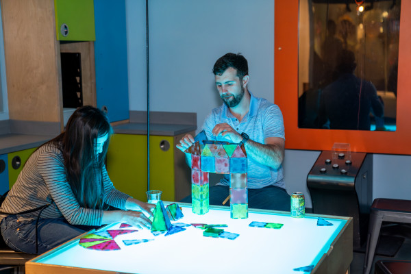 Two People Making Project on Illuminated Table