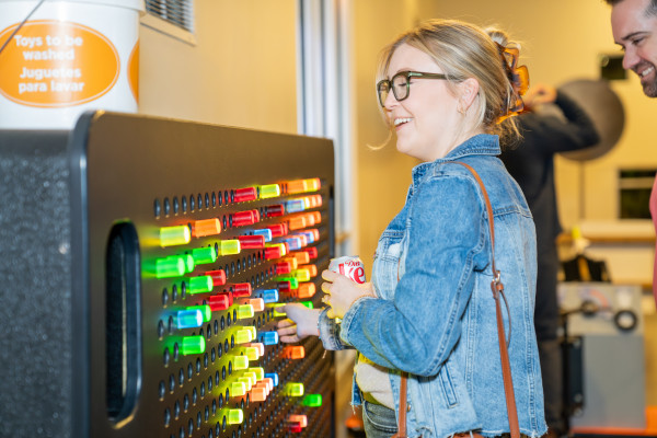 Woman Playing With Giant Pegboard Exhibit