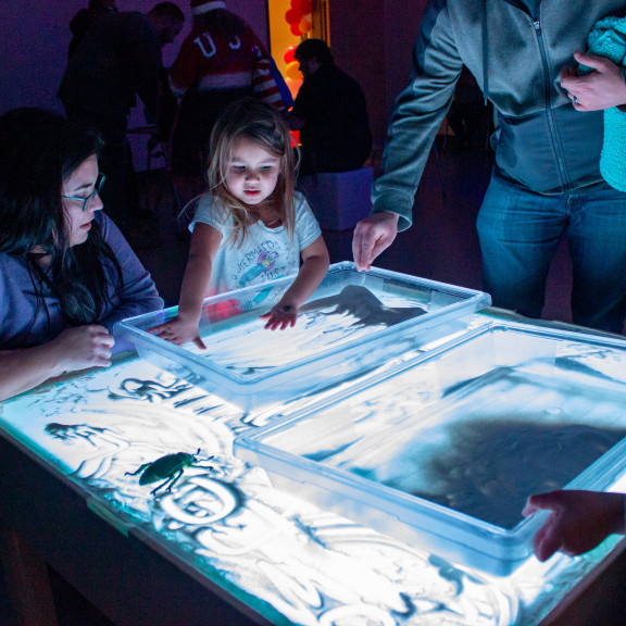 Child Playing With Illuminated Sand Exhibit