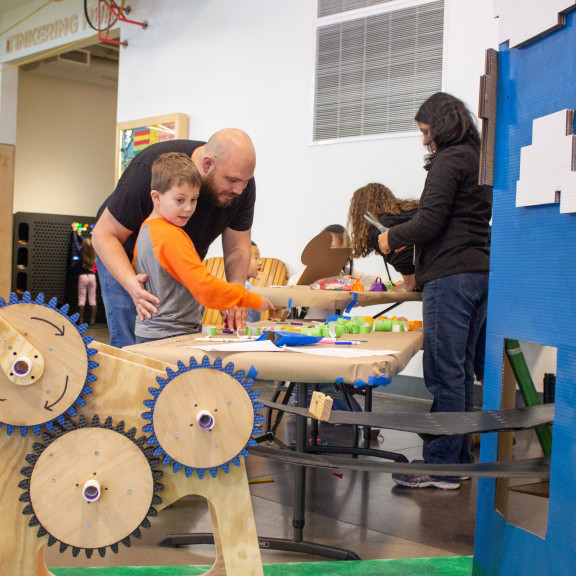 Parent Helping Child Make Paper Link Wish