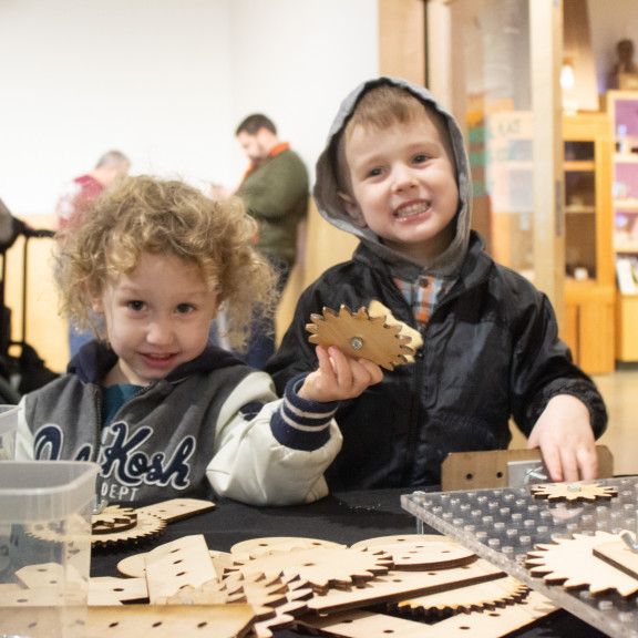 Two Boys Playing With Wooden Gears