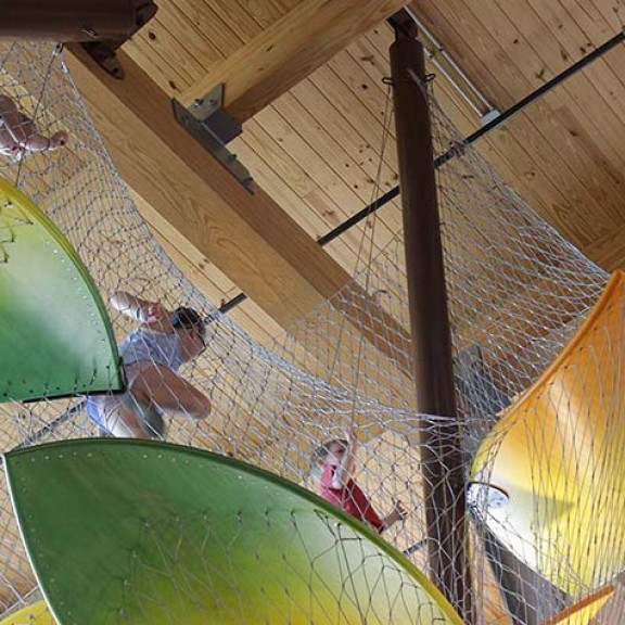 Shot From Below Of Children Playing In Canopy Climber