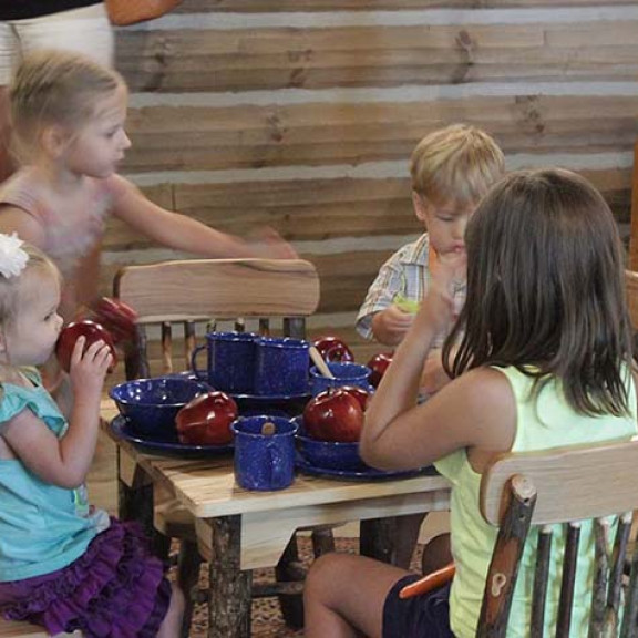 Children Sitting At A Table With Old Enameled Dinnerware