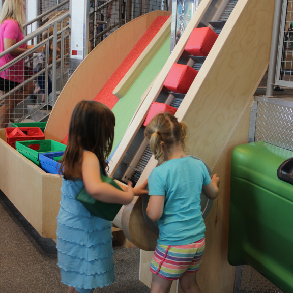 Children Putting Foam Blocks On Vertical Conveyor Belt