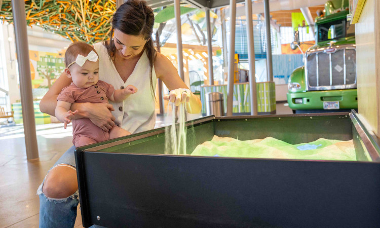 Mom Playing With Child In Topography Sand Box