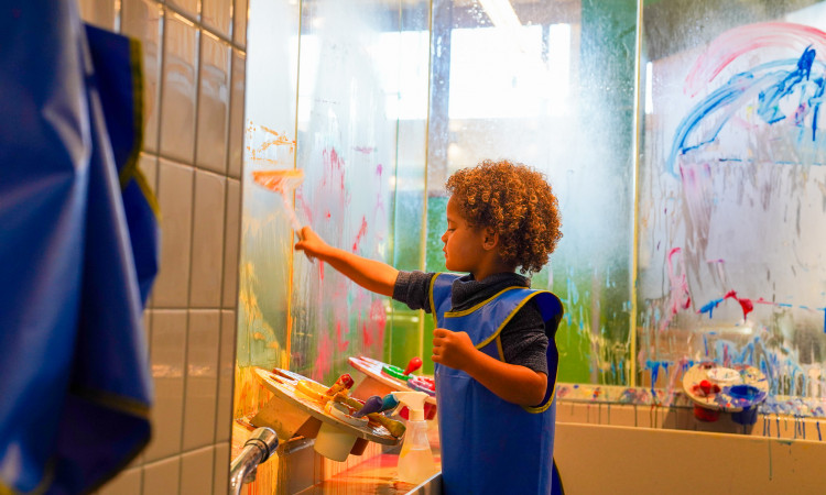 Young Boy Painting On The Glass In Art Studio