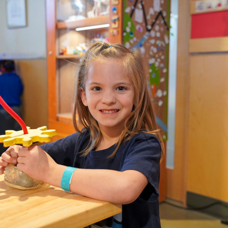 Girl Smiling At Camera With Creation In Hand