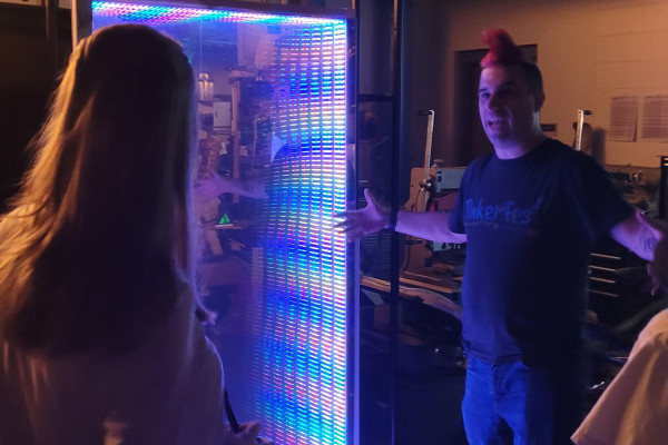 Person With Red Hair Standing In Front Of LED Mirror