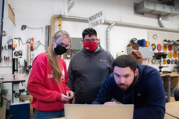 Three Makers Looking At Something On A Laptop