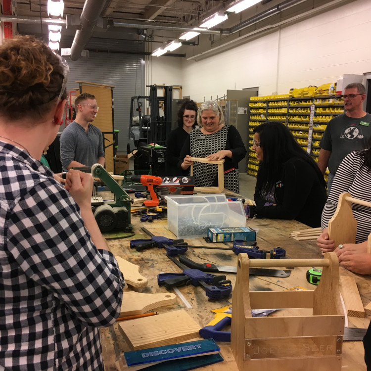 Group Of Adults Learning How To Do Woodworking