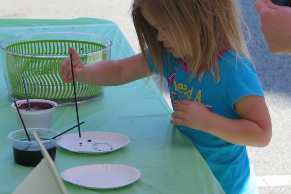 Young Girl Mixing Paints On A Paper Plate Outside