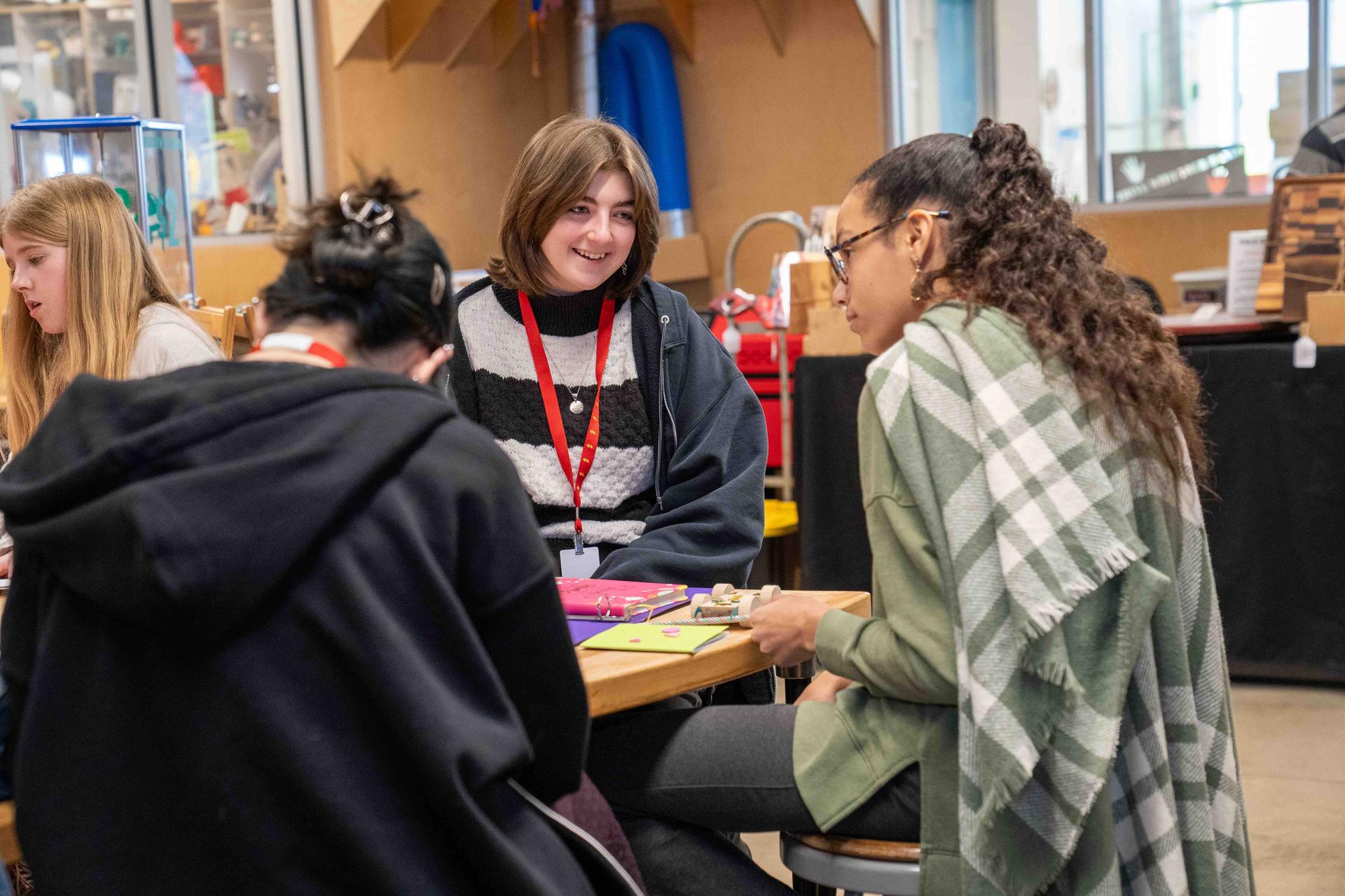 A Group Of Young Women Talking Around a Craft Table