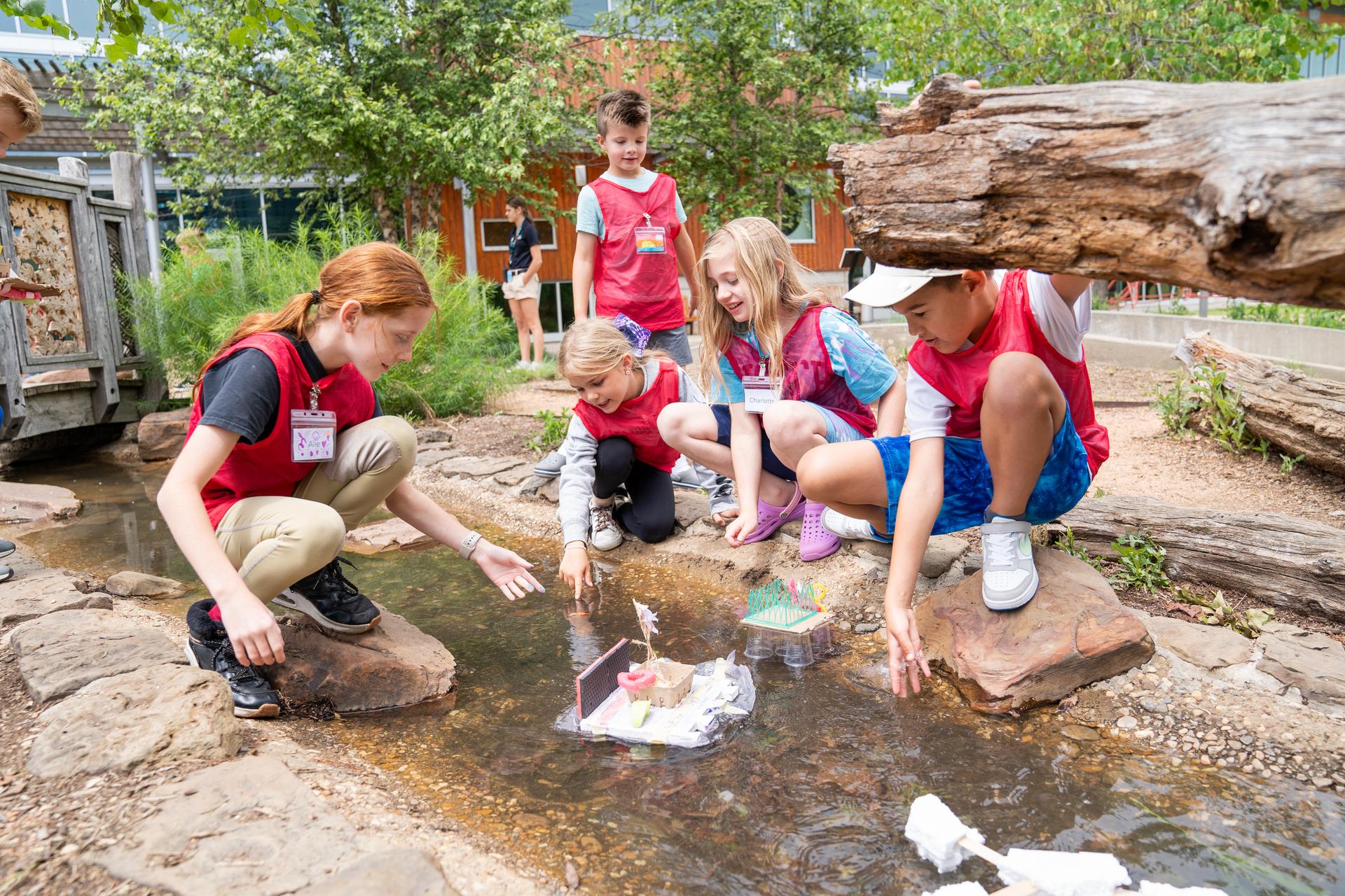 Children Playing In Stream Outside Amazeum