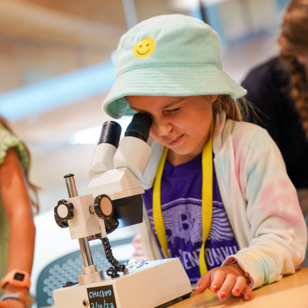 Girl In Bucket Hat Looking Through Microscope