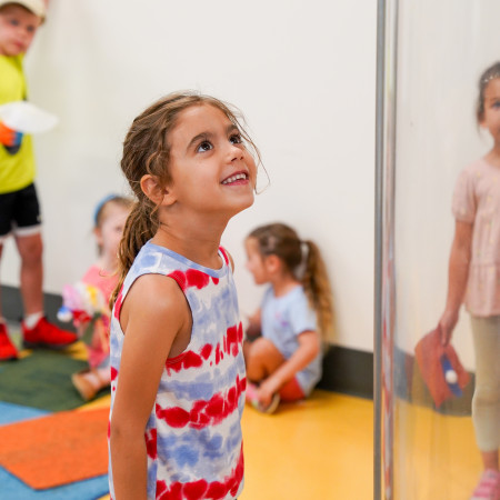 Girl Looking Above And Smiling At An Amazeum Experiment