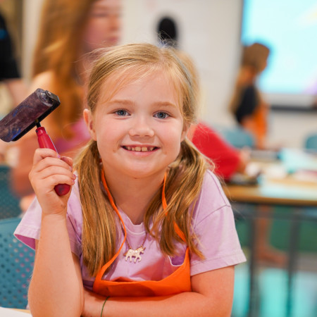 Girl Posing For Camera With A Small Paint Roller In Her Hand