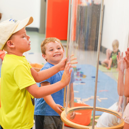 Two Boys Playing With Air Tunnel