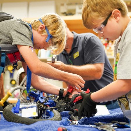 Two Boys Working On A Bicycle On Table