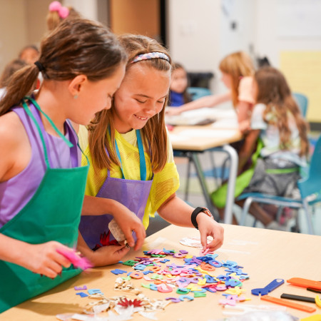 Two Girls Arranging Foam Letters For Project