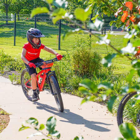 Young Boy Riding Bike On Sidewalk Trail