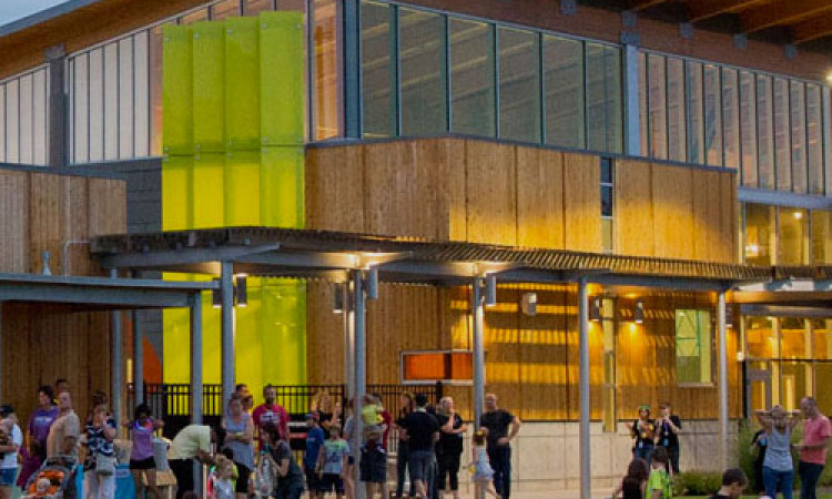 People Standing In Front Of The Amazeum At Dusk