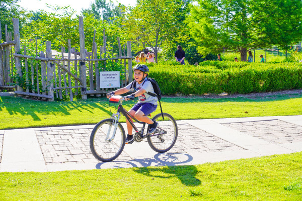 boy smiling happy on bike bright sun